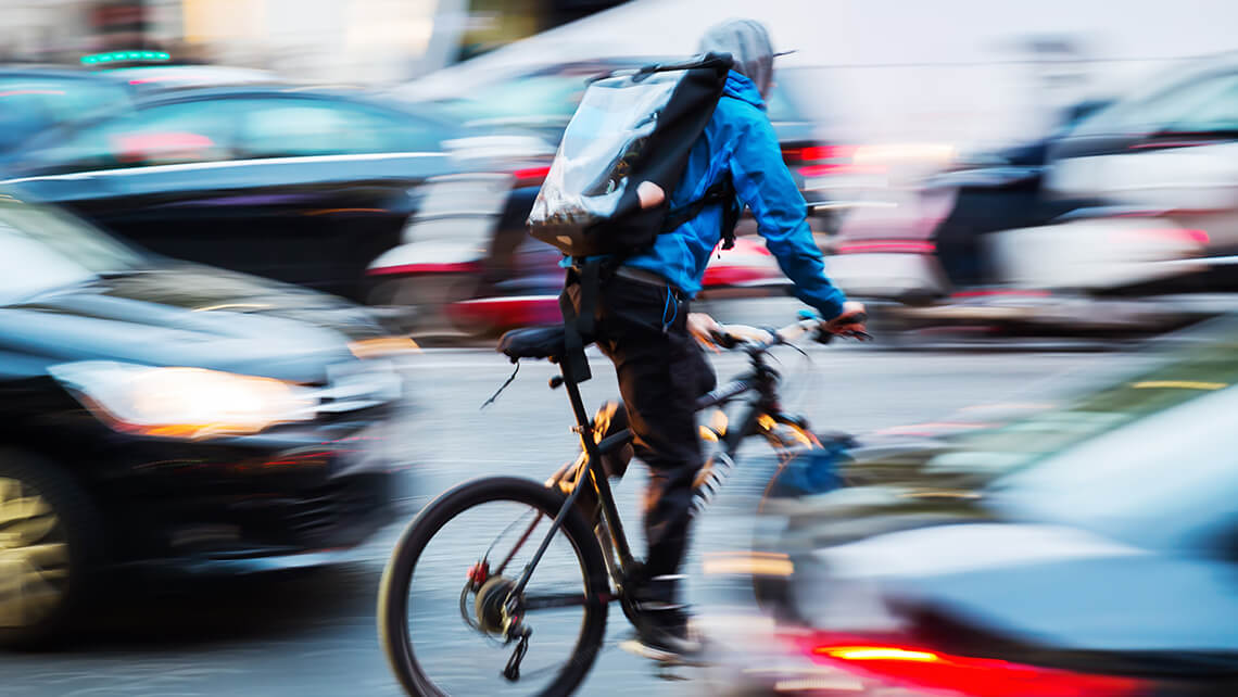 bicylist driving fast through cars